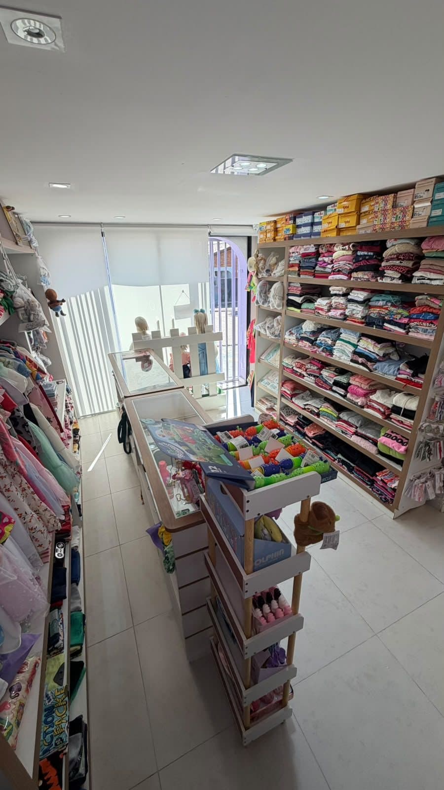 Entrada da loja com vista para a rua e vitrines de produtos infantis