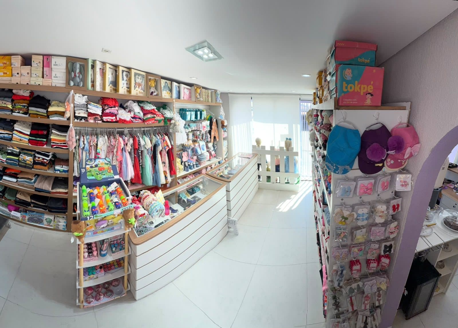 Visão geral da Loja Infantil, com araras de roupas e prateleiras organizadas